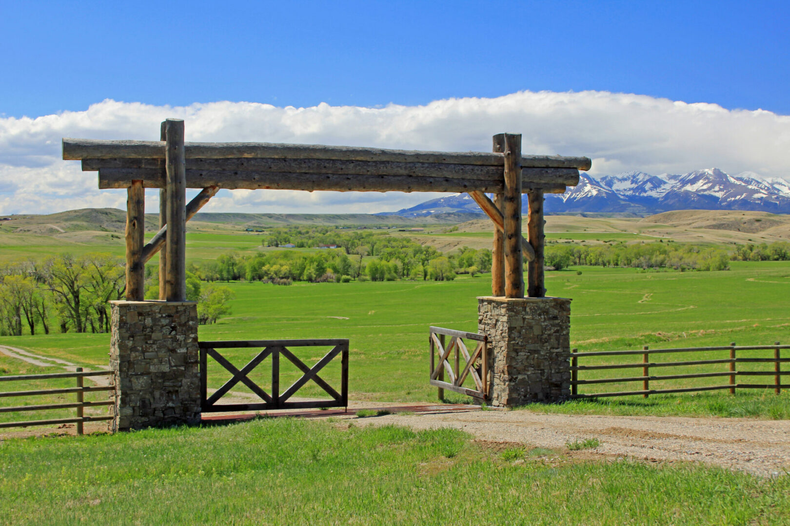 Rustic wooden gate with mountain landscape background.