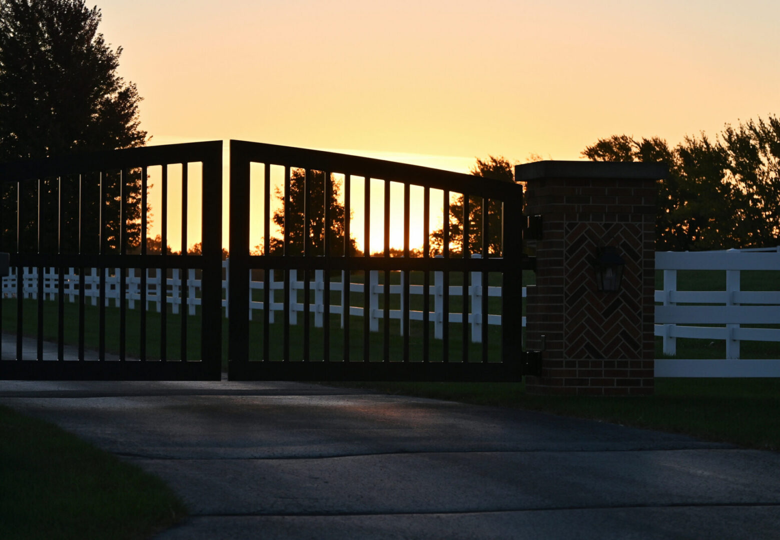 Sunset behind a gate and fence.